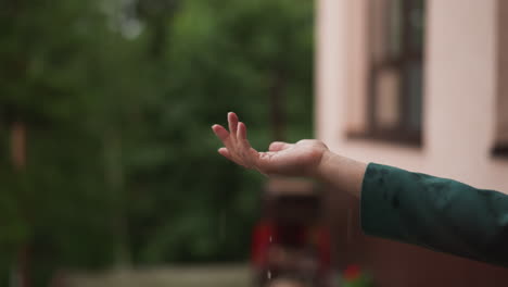 un primer plano de una mano atrapando gotas de lluvia