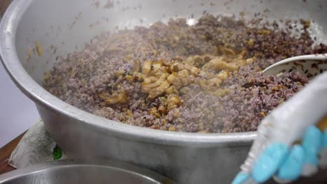 Carne-De-Cerdo-Frita-En-Salsa-De-Soya-Servida-Con-Una-Cuchara-Y-Echada-En-Una-Olla-Grande-De-Arroz-Morado