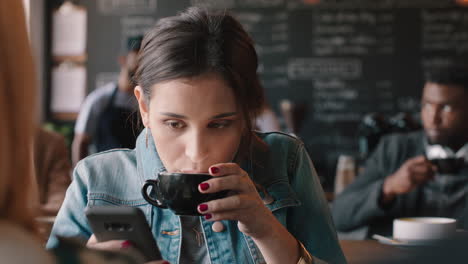mujer hermosa usando un teléfono inteligente bebiendo café en una cafetería enviando mensajes de texto compartiendo mensajes en las redes sociales disfrutando de la tecnología móvil