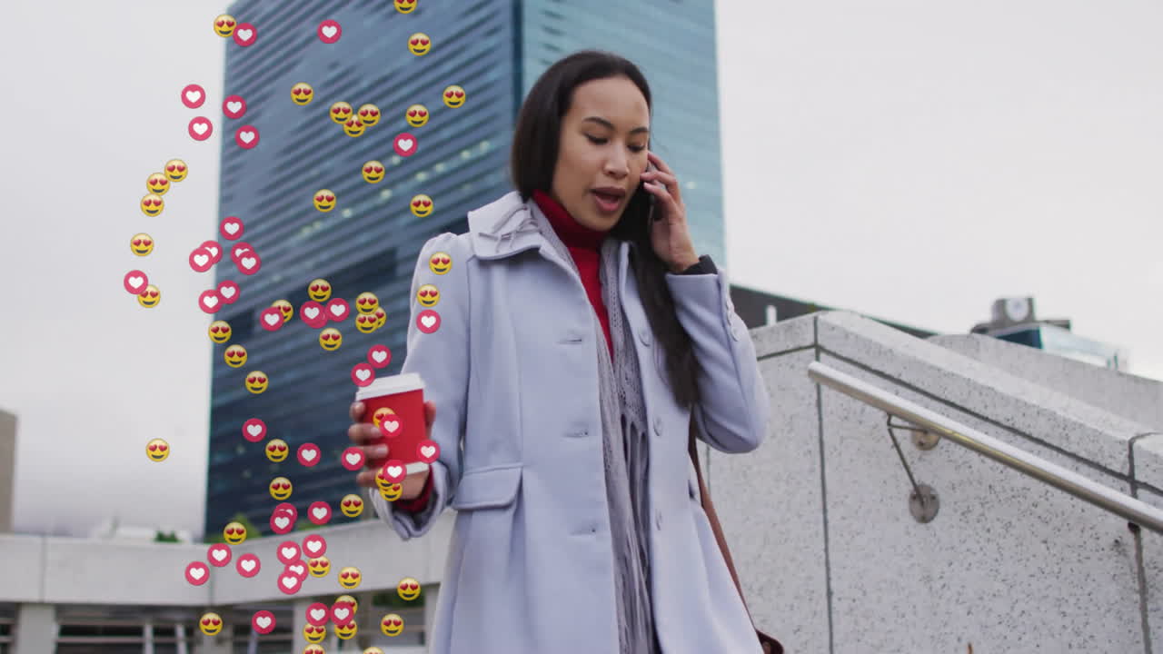 Woman using smartphone and holding coffee cup on plaza steps, showing business tech heart emojis