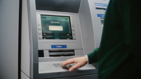 unrecognizable person entering pin code on atm keypad to withdraw money. error message on cash machine display about transaction cancellation due to incorrect pin code. banking equipment. close up.