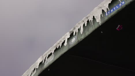 winter in the mountains, frozen roof, water melting from icicles, sniezka mount, slow motion