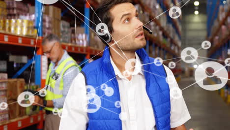 Animation-of-network-of-connections-with-icons-over-caucasian-male-worker-in-warehouse