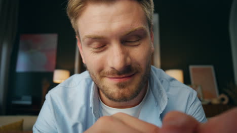 pov smiling man greeting screen at home office. joyful blogger guy waving hand