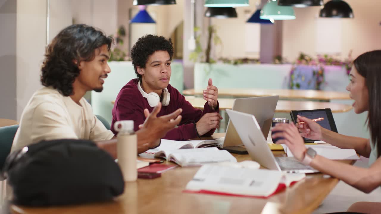 Rekan-rekan di lounge; yang di kiri berbicara, yang di tengah menunjuk laptop, dan yang di kanan menggunakan tablet untuk merencanakan pekerjaan.