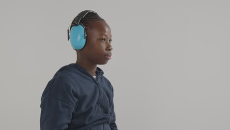 Studio-Shot-Of-Boy-On-ASD-Spectrum-Showing-Sensitivity-To-Loud-Noises-Or-Sounds-Wearing-Ear-Defenders