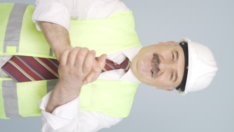 Vertical-video-of-Old-engineer-making-a-sign-of-confidence-at-the-camera.