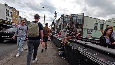 man walking through busy camden town street