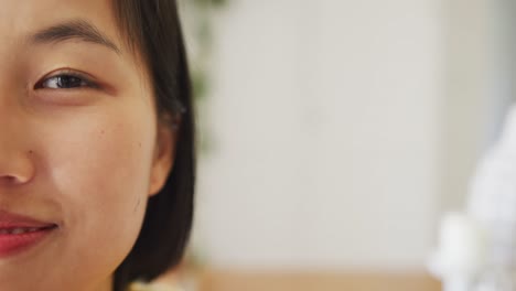 Portrait-of-happy-asian-woman-looking-at-camera-in-living-room