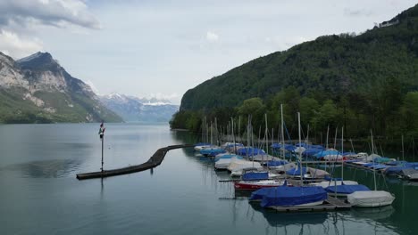 Boats-docked-in-lake-waters-of-Switzerland-creating-serene-scene