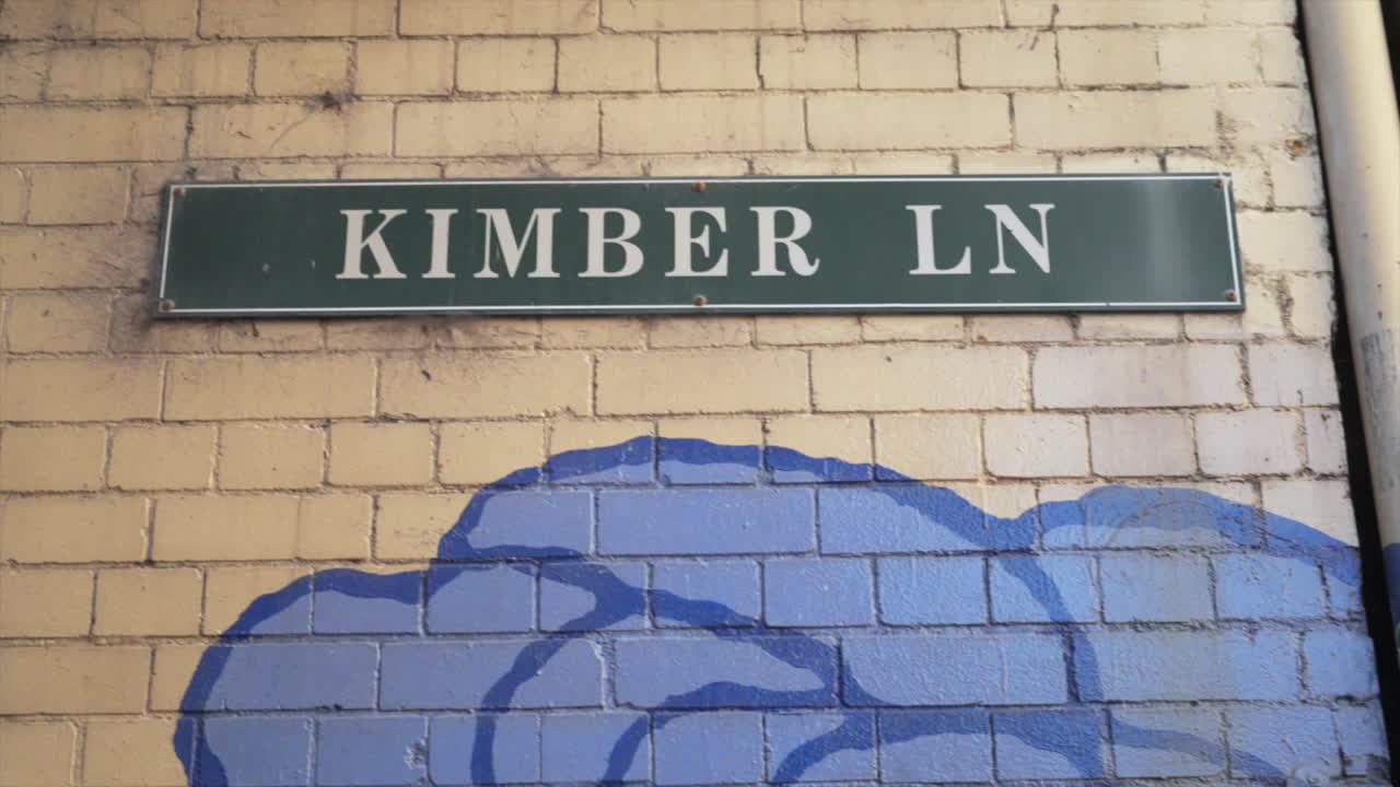 Foto a mano libera del cartello stradale di Kimber Lane montato su un muro di mattoni a Chinatown, Haymarket, Sydney
