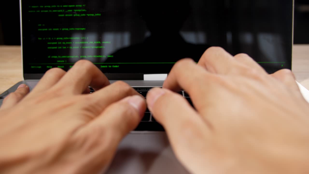 Hands Typing on a Laptop with Code on Screen
