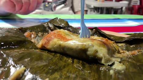 close up of a tamales served on banano leaf traditional mexican food