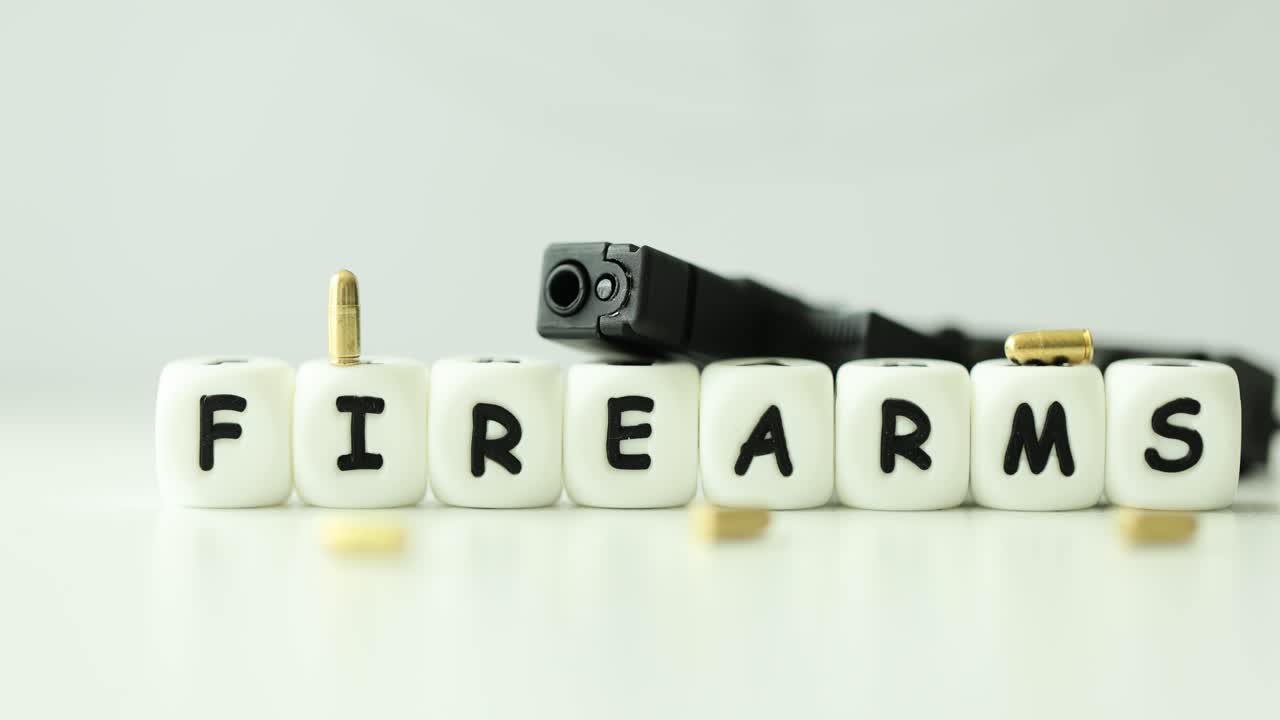 Firearms Word Spelled with Letter Blocks, Featuring a Handgun and Ammunition