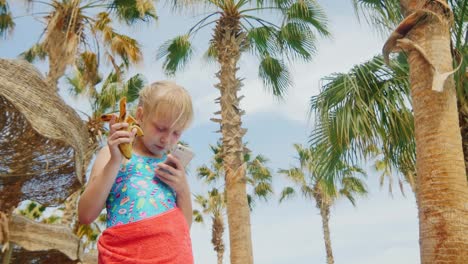 Funny-Girl-Eating-A-Banana-And-Plays-On-The-Smartphone