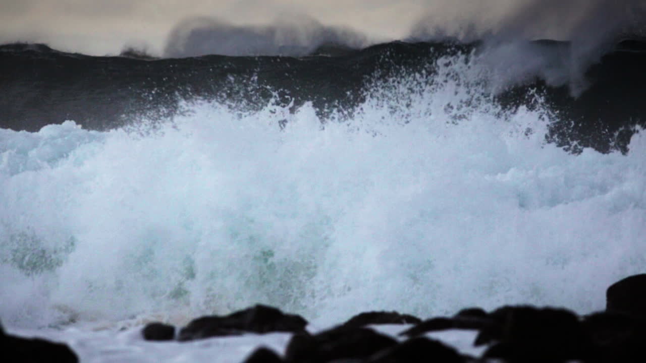 거대한 파도가 굴러와 바위가 많은 해안선에 충돌합니다.