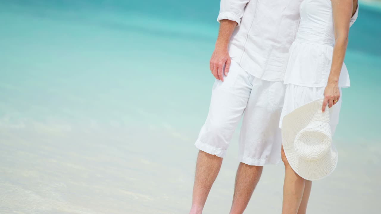 매력적인 백인 부부가 해변에서 휴가를 즐기고 있습니다.