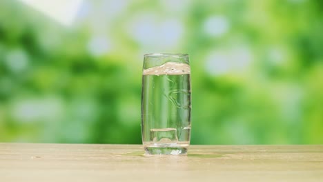 glass of water with ice on wooden table