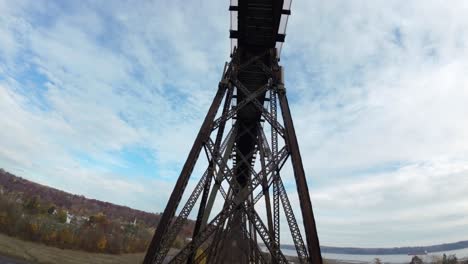 fpv drone flying under railroad bridge, going down from up