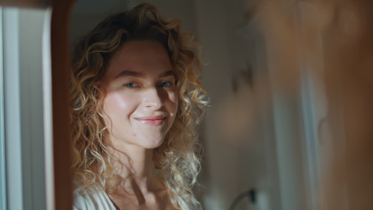 Smiling woman mirror reflection in warm sunlight. Portrait happy blonde posing