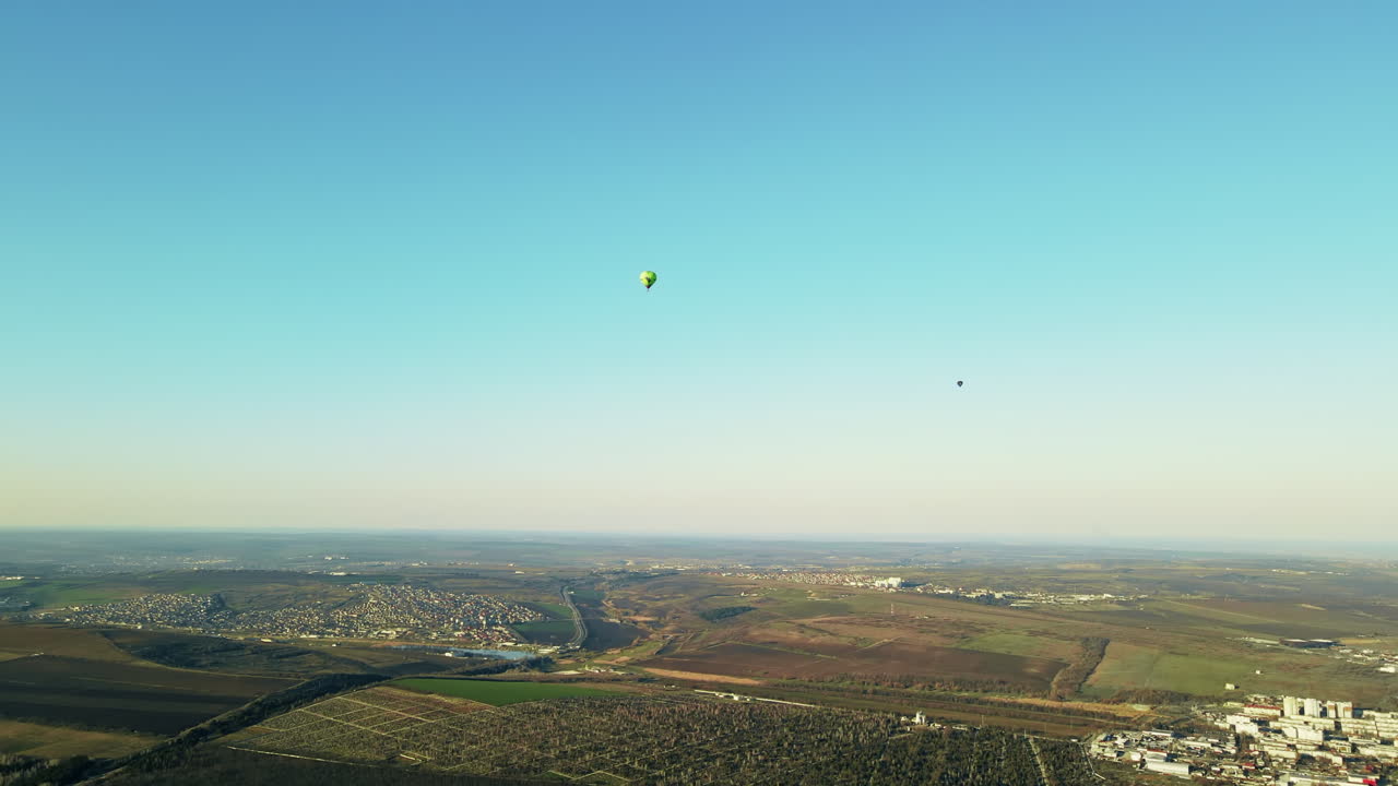 Aerial drone view of two hot air baloons flying above the land of Moldova, hills, clean sky