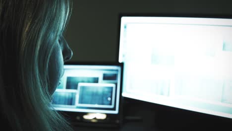 Woman-working-in-home-office-on-bright-screen-in-dark-room