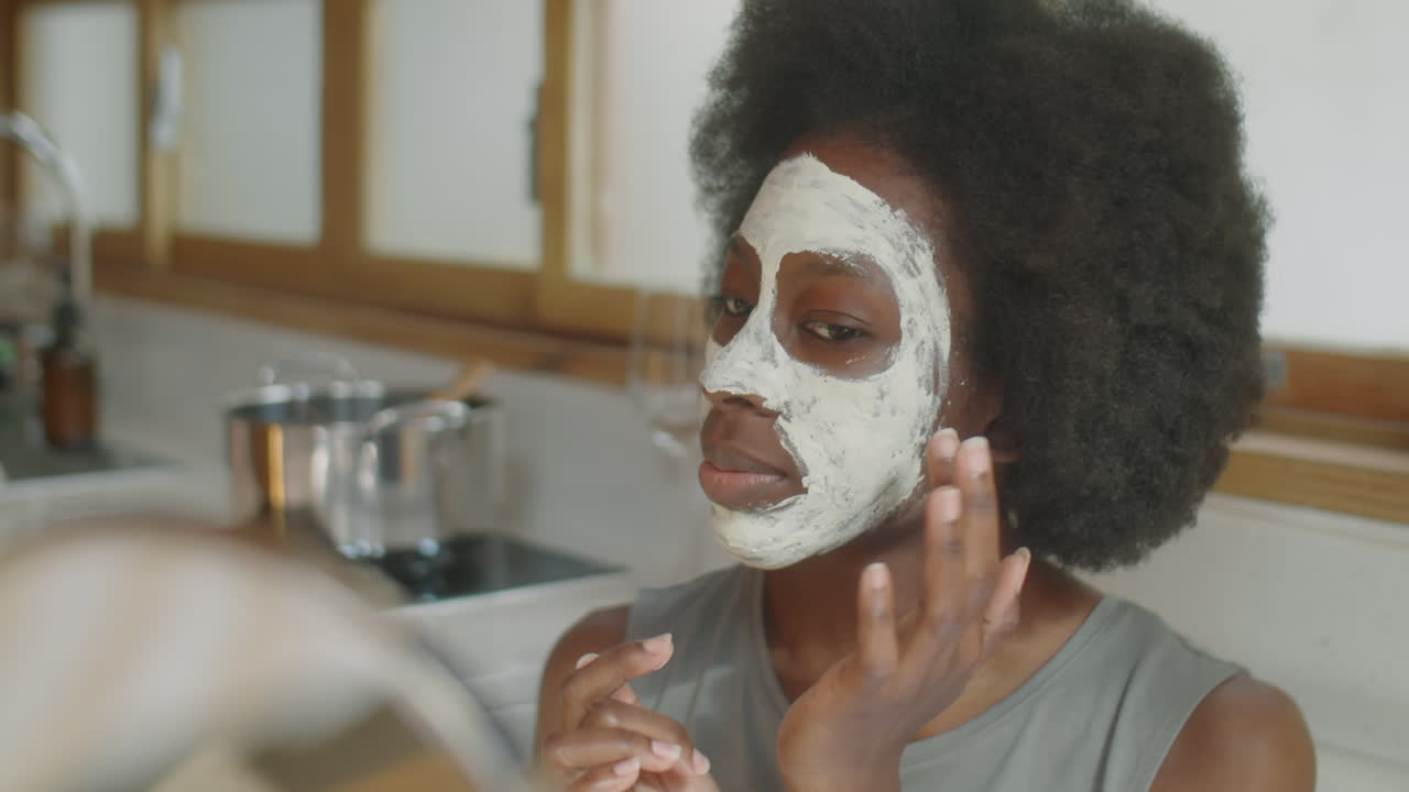 African American Woman Applying Clay Mask at Home
