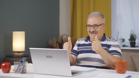 Home-office-worker-old-man-applauding-what-he-sees-on-laptop.