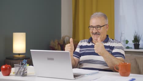 home office worker old man applauding what he sees on laptop.