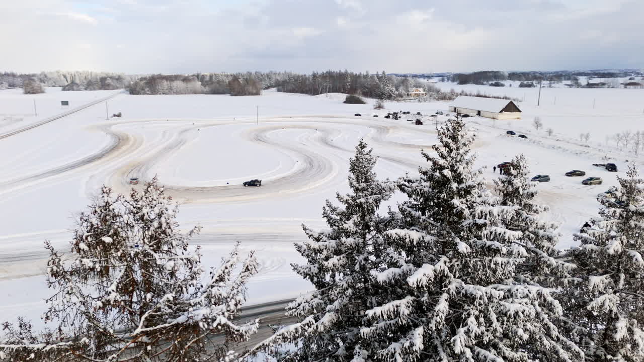 Aerial view around trees with race cars on a ice track background, winter day