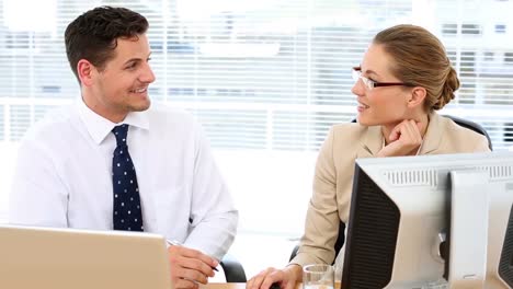 Focused-business-team-speaking-together-at-desk