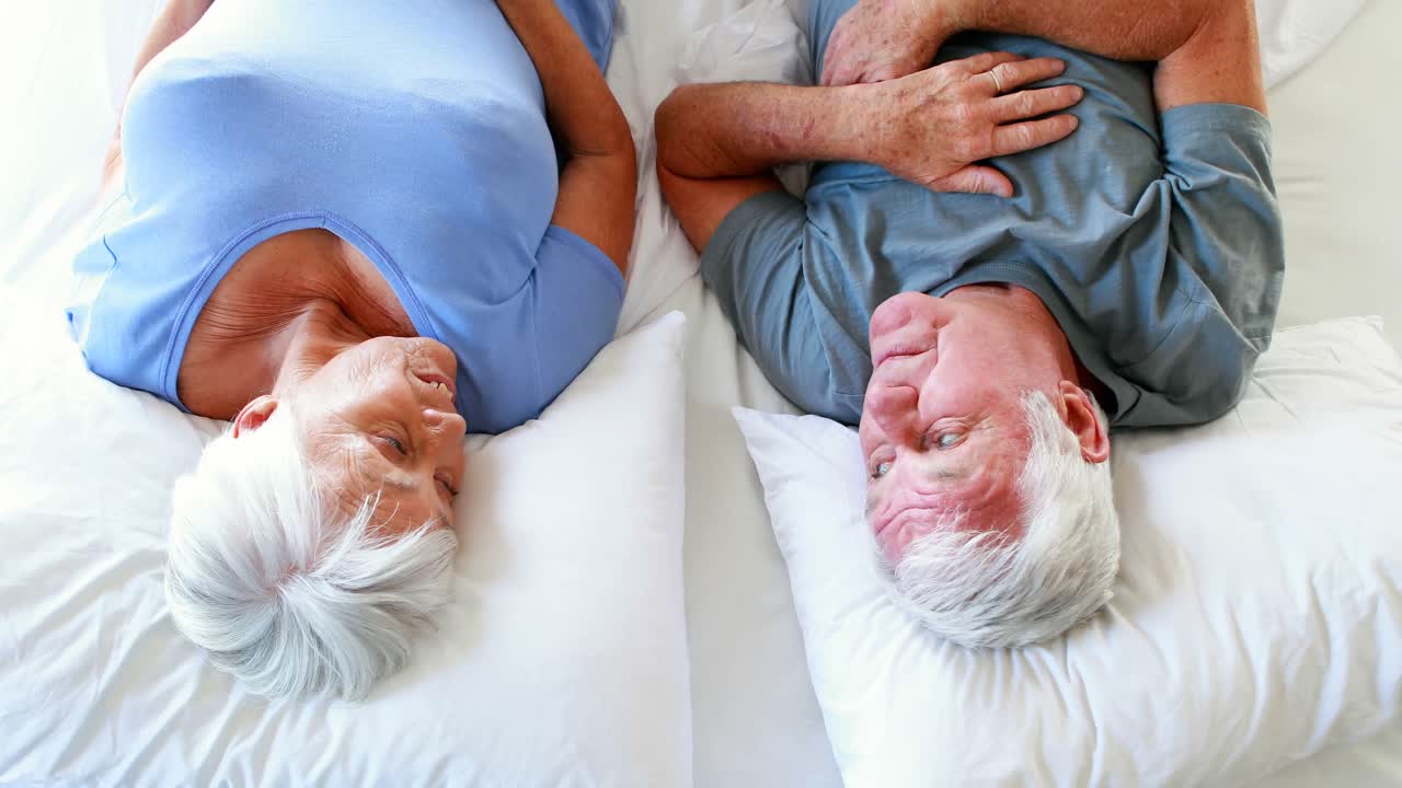 Felice coppia senior sdraiato sul letto