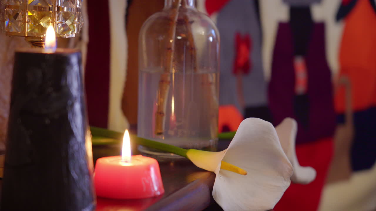 flores de lirio de calla en un ambiente relajante iluminado por velas con pared de piedra natural y una agradable profundidad poco profunda del campo con decoraciones indígenas rústicas