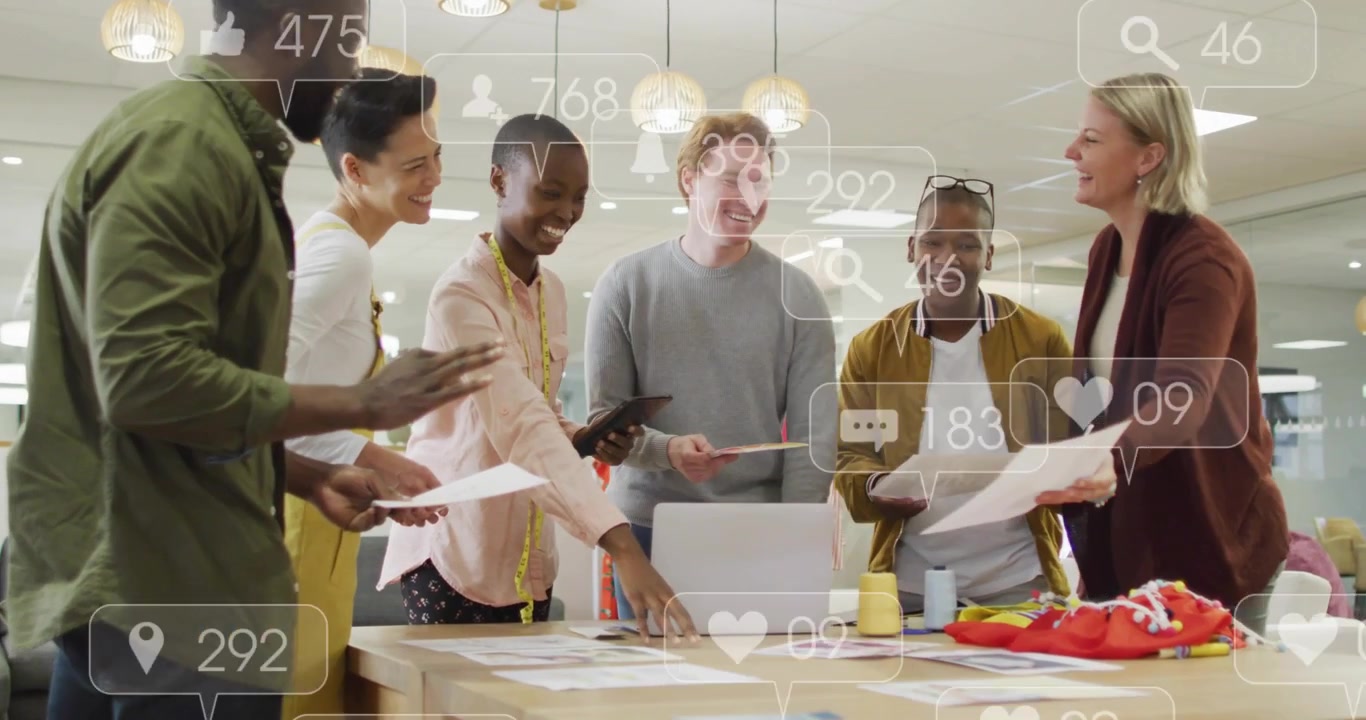 Design team gathering around table, tapping laptop and causing social overlays, assessing mockups