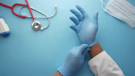 doctor putting on gloves with medical equipment