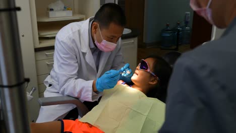 Dentista-Masculino-Examinando-A-Un-Paciente-Con-Herramientas-4k