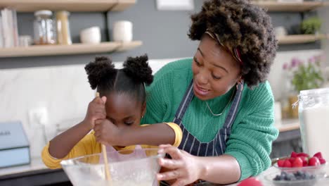 Feliz-Madre-E-Hija-Afroamericana-Preparando-Masa-En-Un-Tazón-En-La-Cocina,-Cámara-Lenta
