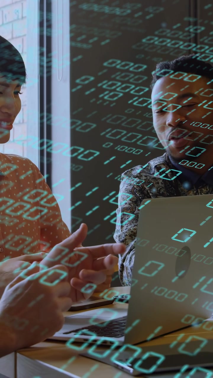 Vertical video: Woman pointing at laptop starting tech meeting, man nodding, binary code sweeping