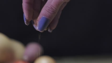 close up of woman hand sprinkling spice