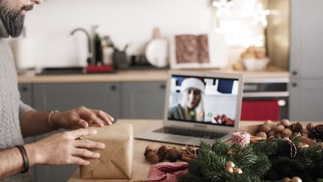 Adult-man-packing-Christmas-gift-with-girlfriend-by-video-chat