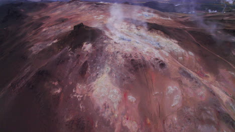 Aerial-of-volcanic-mountain-smoking-in-Hverir-geothermal-area,-Iceland