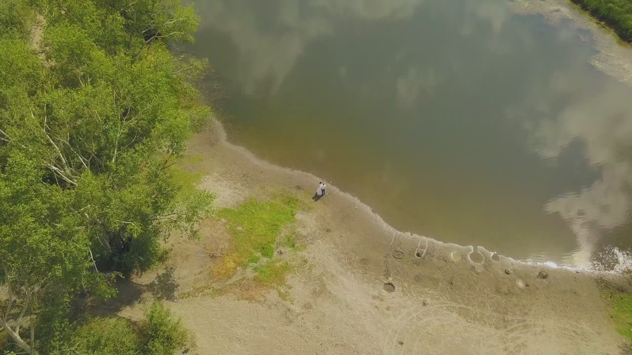 신랑 과 신부 가 호수 의 모래 연안 에 서 있는 움직임