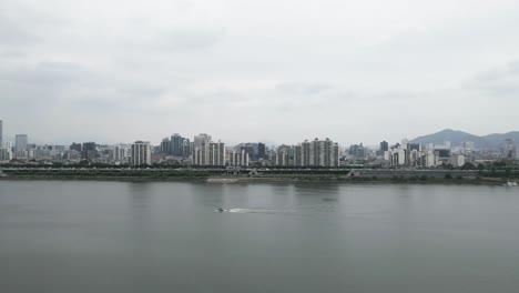 Aerial-drone-shot-flying-over-Han-River-towards-Seoul-city,-South-Korea