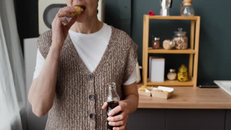 a person enjoying fast food and a beverage in a kitchen
