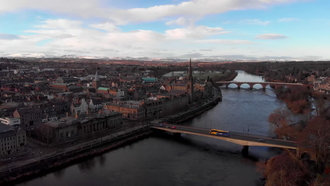 sobrevuelo aéreo del río tay con paisaje urbano durante el día soleado y nublado en perth, escocia