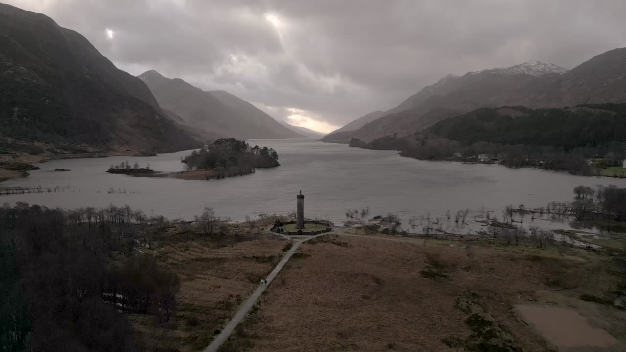monumento de glenfinnan junto al lago con las tierras altas escocesas en el fondo, cielo nublado, vista aérea