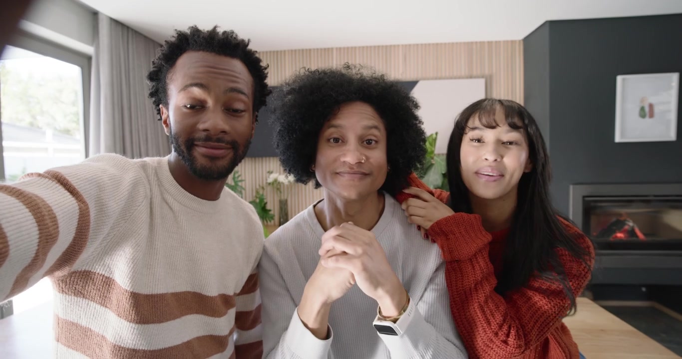 African American friends left starting selfie with phone, center speaking at home