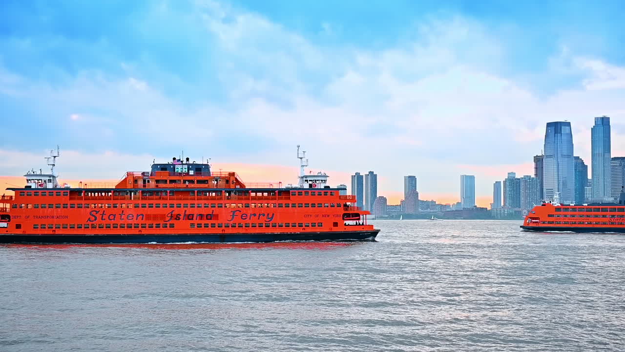 Orange ferry boats and motorboat move by the vast river at sunset time. Skyline of modern New York at backdrop