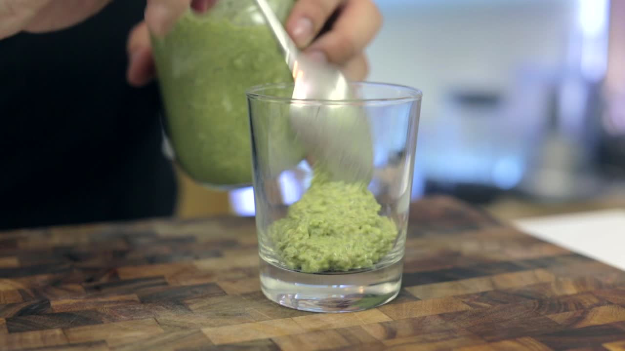 llenar un vaso con budín de matcha chia y luego pegar rodajas de kiwi en el vaso con fines decorativos