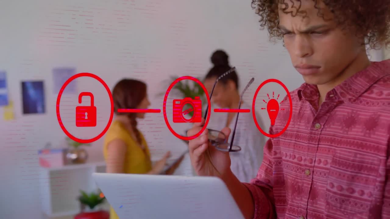 animación de tres iconos de medios rojos conectados sobre un hombre en una oficina casual usando una computadora portátil